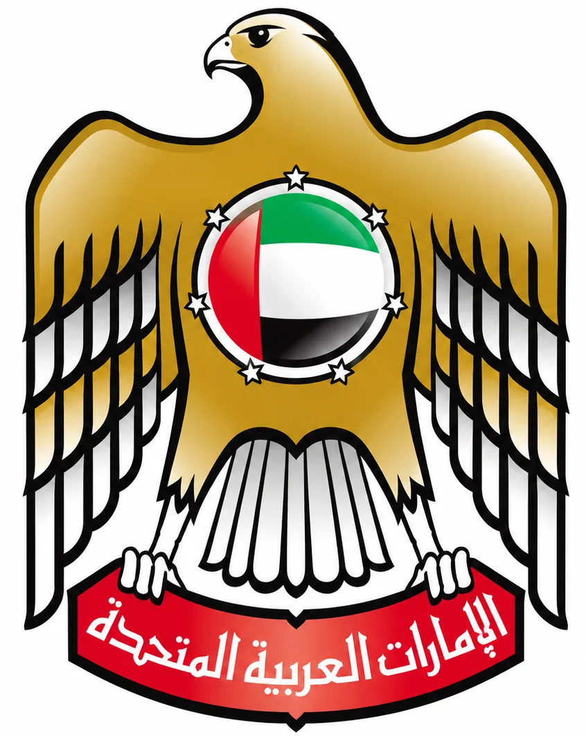 Golden eagle emblem with outstretched wings and a circular UAE flag badge on its chest, above a red banner reading الإمارات العربية المتحدة.